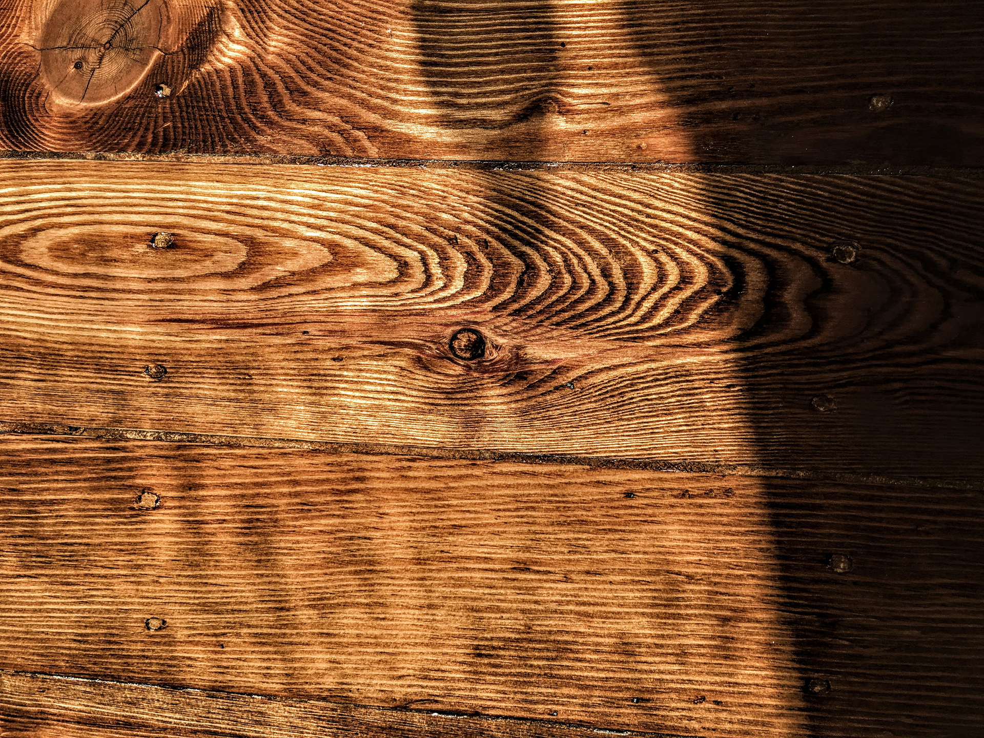 Photo of a dark brown wood floor in closeup.