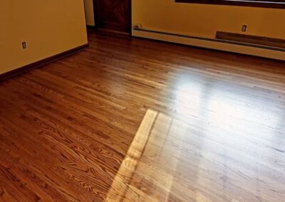 Image of a newly refinished wood floor next to a sunny window