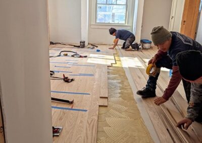 Photo of JAK employees installing a new wood floor