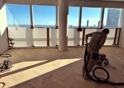 Photo of a JAK employee sanding parquet floors in a highrise