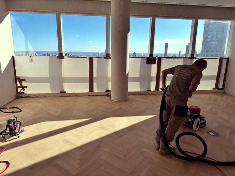 Photo of a JAK employee sanding parquet floors in a highrise