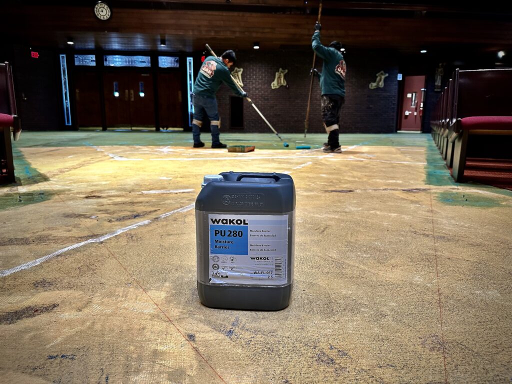 Applying Wakol PU280 moisture barrier to church sanctuary concrete subfloor