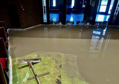 Self-leveling compound being smoothed at sanctuary entrance during pour