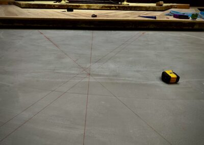 Chalk layout lines over self-leveled subfloor defining centerline and diagonal floor layout