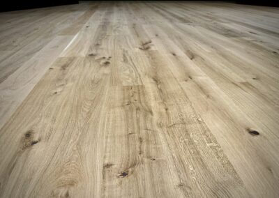 Close-up of 7-inch wide European white oak flooring highlighting natural knots, quarter-sawn markings, and grain variation