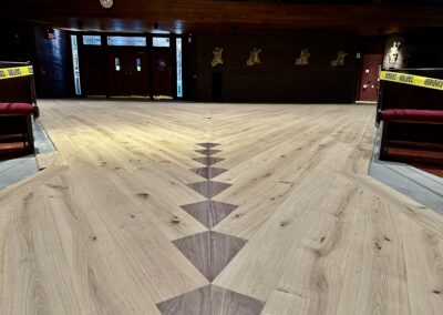 Walnut diamond inlays set within European oak floor between sanctuary pews