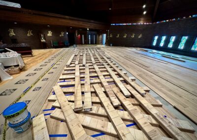 European white oak planks stacked in a basket-weave pattern inside Saint Thomas More Church during floor racking