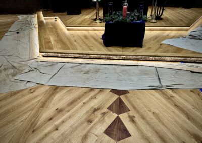 Custom European white oak stair risers staged under their designated locations with integrated LED lighting illuminated beneath the nosing