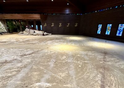 Right side of church sanctuary with carpet fully removed exposing concrete subfloor and adhesive